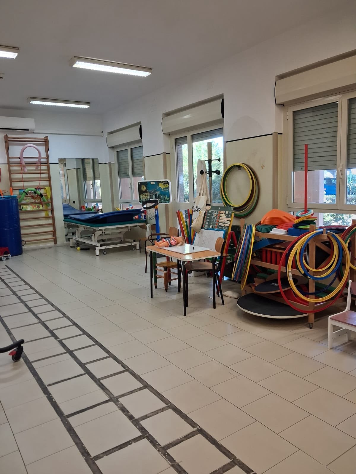 Sala per la riabilitazione con cerchi, lettino e percorso a pavimento