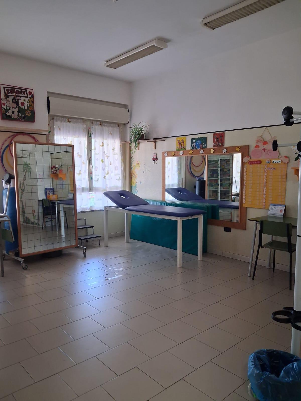 Sala per la fisioterapia con lettino e specchio